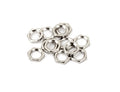 Twelve small, hexagonal silver metal nuts arranged in a scattered pile on a white surface.