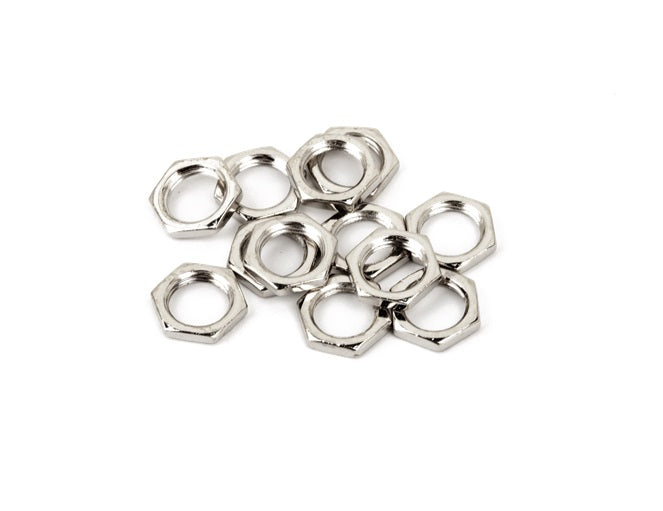 Twelve small, hexagonal silver metal nuts arranged in a scattered pile on a white surface.