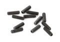 Twelve small black threaded screws arranged loosely on a white background.