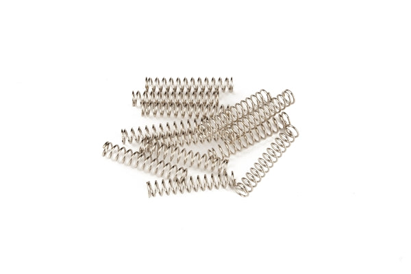 Twelve silver metal coil springs arranged on a white background.