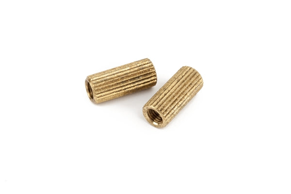 Two small brass-colored threaded cylindrical inserts with ridged exteriors on a white background.