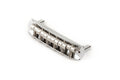 Metal guitar bridge assembly with six adjustable saddles and screws, shown on a white background.