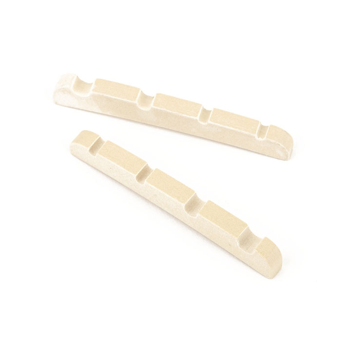 Two beige pre-slotted string nuts for a bass guitar displayed on a white background.