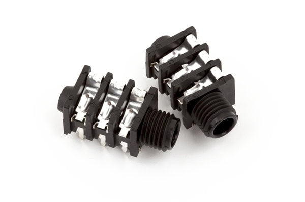 Two black 6-pin stereo audio jacks with metal contacts on a white background.