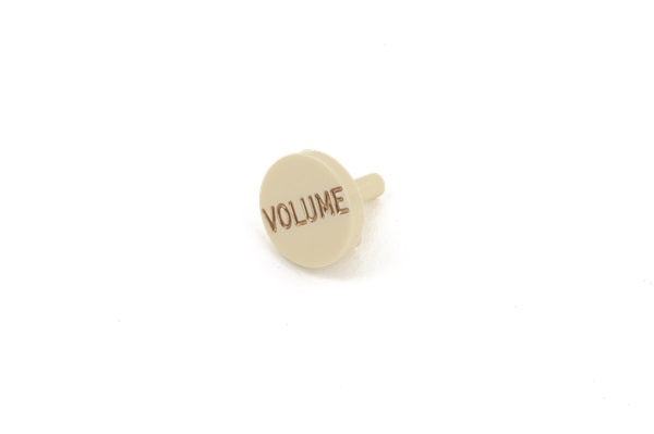 A single aged white plastic volume knob cap with brown text on a white background.