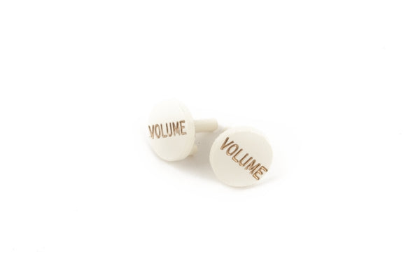 Two white circular knob caps labeled 'VOLUME' in brown text on a white background.