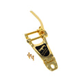 Gold-colored vibrato tailpiece with lever and four gold screws on a white background.