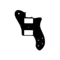 Black guitar pickguard with white and black layers and multiple screw and control holes.