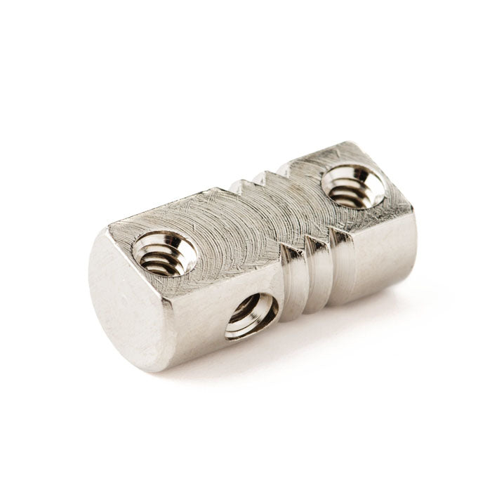 Single silver metal guitar or bass bridge saddle with three threaded holes and ridged top surface.
