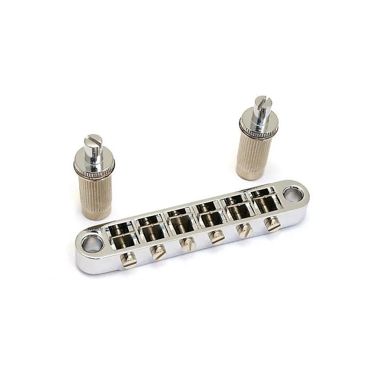 Silver metallic guitar bridge component with six adjustable saddles and two separate cylindrical posts on white background.