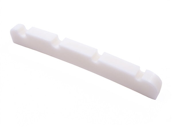 White pre-slotted string nut for a bass guitar with four string slots, isolated on white background.
