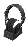 Black Yamaha YH-WL500 wireless headphones resting on a black charging dock with indicator lights.