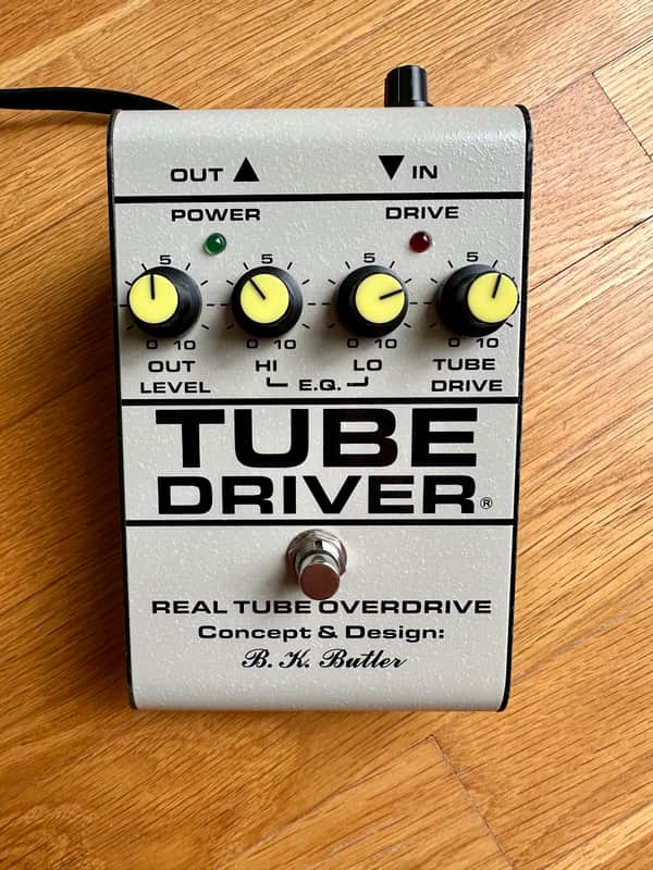 A BK Butler Tube Driver guitar effects pedal in a rectangular steel enclosure, with a row of rotary knobs across the top panel, two small LED indicators, and a footswitch at the front.