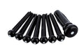 Set of seven black bridge pins with white dots, including one shaped differently, on a white background.