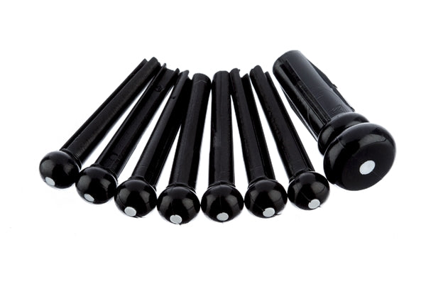 Set of seven black bridge pins with white dots, including one shaped differently, on a white background.