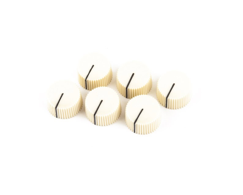Six cream-colored plastic knobs with black indicator lines arranged on a white background.