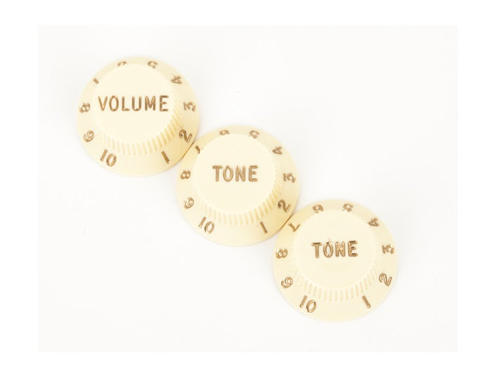 Three off-white plastic control knobs labeled Volume and Tone with numbers 1 to 10.