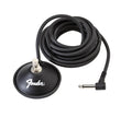 Black round footswitch with a single button and attached coiled cable with right-angle 1/4 inch plug