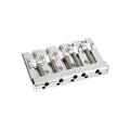 Chrome five-string guitar bridge assembly with visible spring-loaded saddles and FENDER engraving.