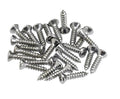 A group of silver metal screws with flat, rounded heads are scattered on a white background.