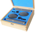 Open wooden case with blue foam insert containing two Schoeps CMC 6 MK 2 microphones, clips, and foam windshields.