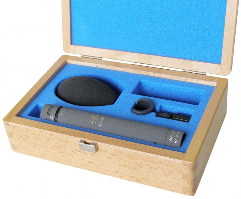 Gray cylindrical microphone with foam windshield and clip in blue foam-lined wooden case