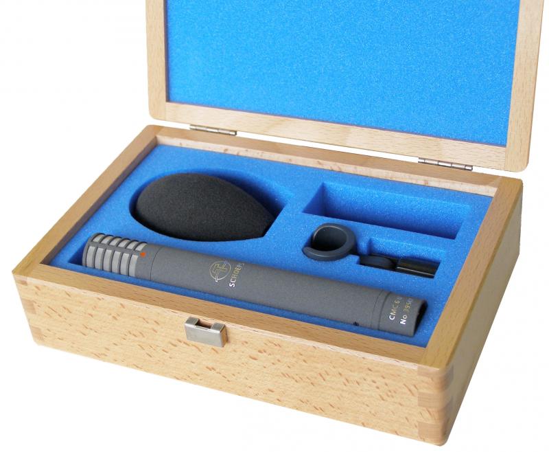 Gray microphone with foam windscreen and clip in a blue-foam lined wooden case.