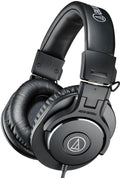 Black over-ear headphones with padded headband and ear cups, featuring visible audio-technica logo and wired connection cable.