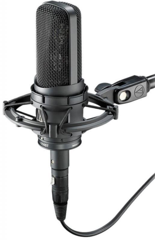 Black studio microphone with shock mount and attached cable shown from angled view.
