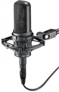 Black studio microphone with shock mount and attached cable shown from angled view.
