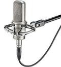 Silver studio condenser microphone with shock mount attached and an XLR-type audio cable connected.