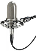Silver condenser microphone with shock mount attached to a mounting arm with cable connected.