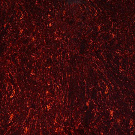Close-up of a red tortoise shell patterned plastic sheet with black and orange details.