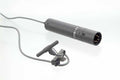 Black lavalier microphone with clip and attached cable shown against white background.