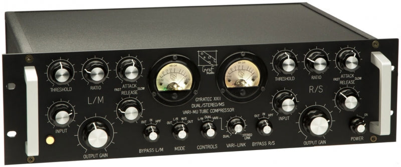 Black audio processor unit with multiple knobs, switches, and two analog meters on the front panel.