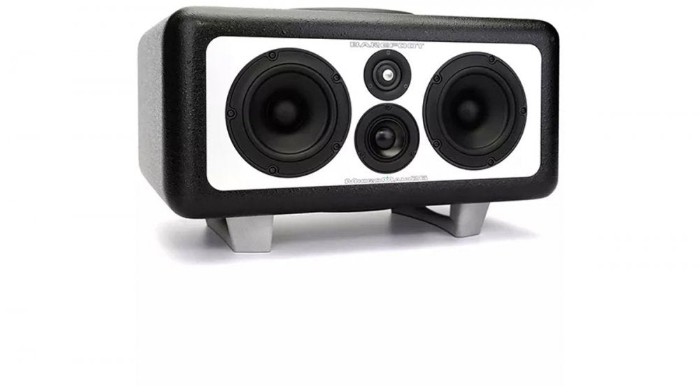 Black and white studio monitor speaker with four drivers and silver feet on a white background.
