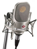 Silver Neumann microphone mounted in a shock mount on a stand with an XLR cable connected.