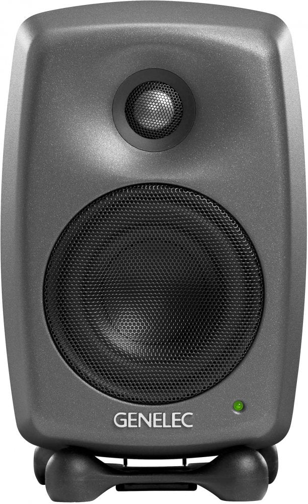 Front view of a gray Genelec speaker with black speaker grills and a green indicator light on a black stand.