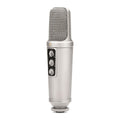 Silver studio microphone with three rotary knobs and a metallic mesh grille on top.