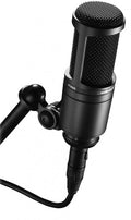 Black condenser microphone labeled AT2020 mounted on a stand arm with cable attached