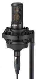 Black Sony microphone with shock mount and XLR cable attached on a stand.