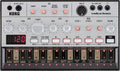 Top view of a KORG Volca Bass synthesizer with multiple knobs, buttons, LED display, and audio/MIDI connectors.