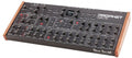 Black synthesizer module with multiple knobs, switches, and wooden side panels labeled Prophet Rev2.