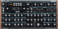 Top view of a Novation Peak synthesizer showing control knobs, buttons, and display screen.