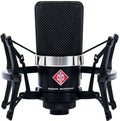 Front view of a black Neumann microphone with a shock mount and red logo on the front.