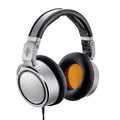 Silver and black over-ear headphones with orange inner ear pads and attached cable, shown angled.