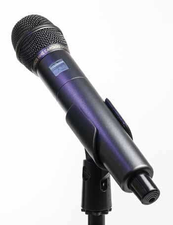 Handheld black microphone with a grille and visible button on a stand against a plain background.