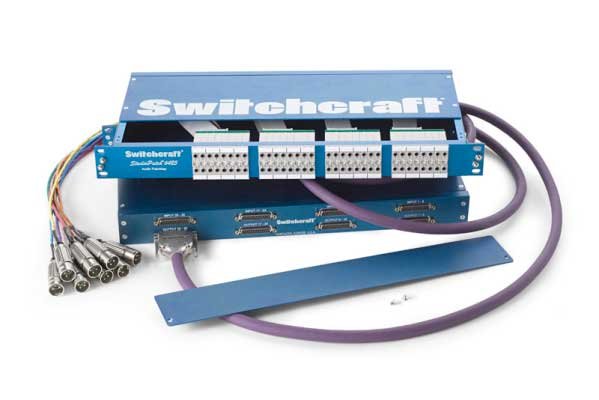 Blue Switchcraft StudioPatch 9425 audio patchbay with cables and D-sub connectors on a white background.