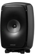 Black studio monitor speaker with a central driver and a green indicator light on a black isolating stand.