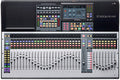 A digital mixer with 64 faders, multi-colored buttons, rotary knobs, and a touchscreen display.